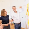 Mann und Frau stehend vor Whiteboard