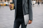 K&ouml;rper von Mann in Anzug mit Kaffebecher und Laptop in der Hand