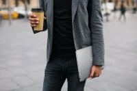 K&ouml;rper von Mann in Anzug mit Kaffebecher und Laptop in der Hand