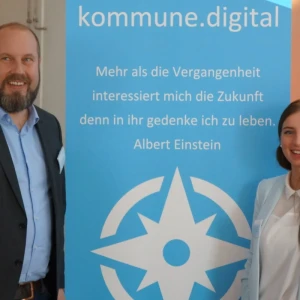Mann und Frau vor Ausssteller mit Aufschrift "kommune digital"